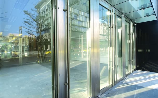 Glass and steel storefront doors along a city sidewalk